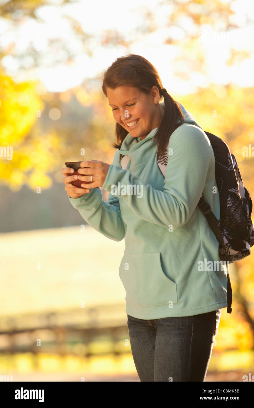 Caucasian teenager using cell phone outdoors Banque D'Images