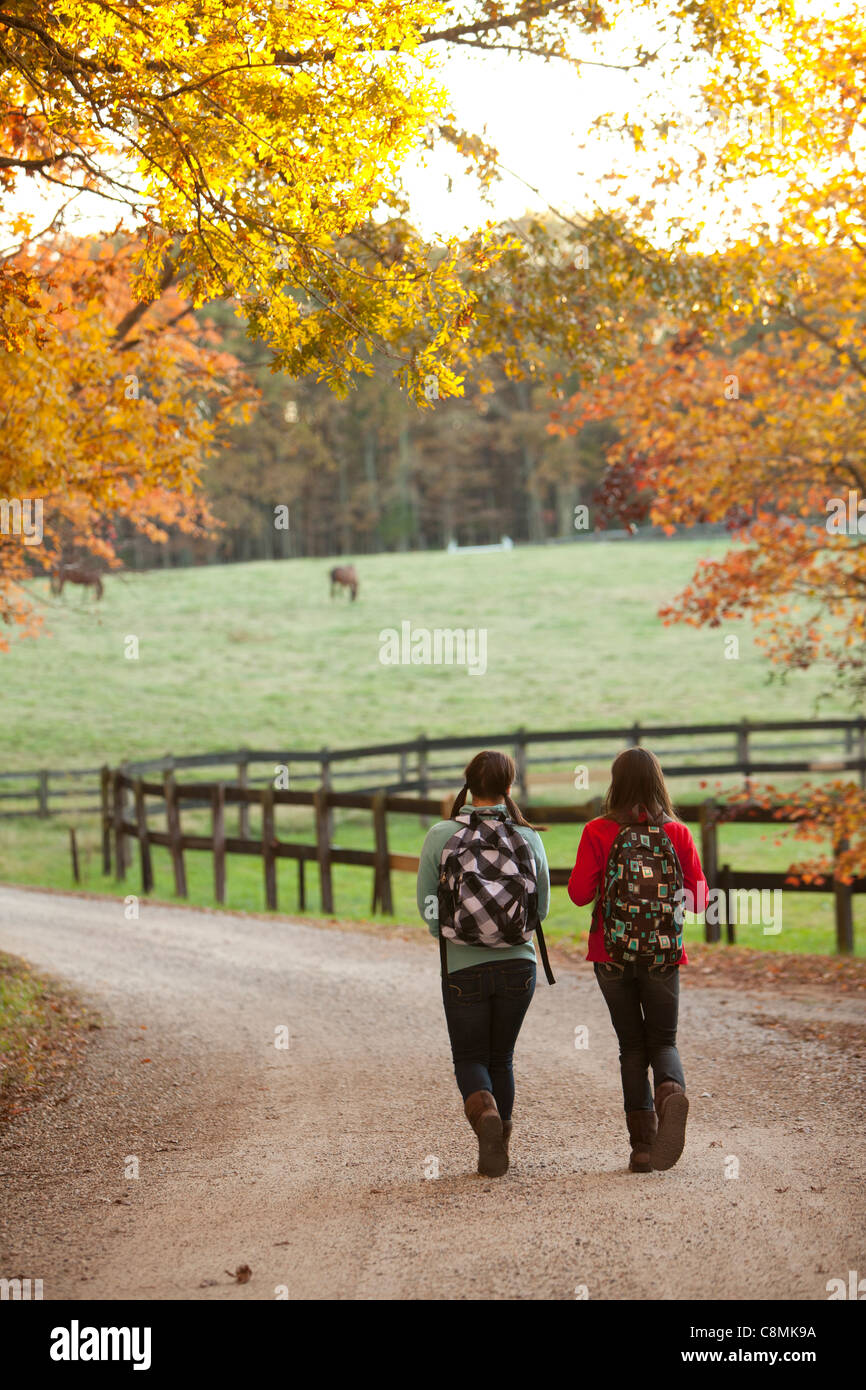 Caucasian girls walking on road in countryside Banque D'Images