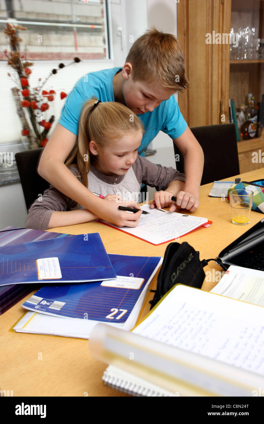 Frère et sœur, à la maison, de l'apprentissage pour l'école, d'aider les uns les autres, faire ses devoirs. Banque D'Images