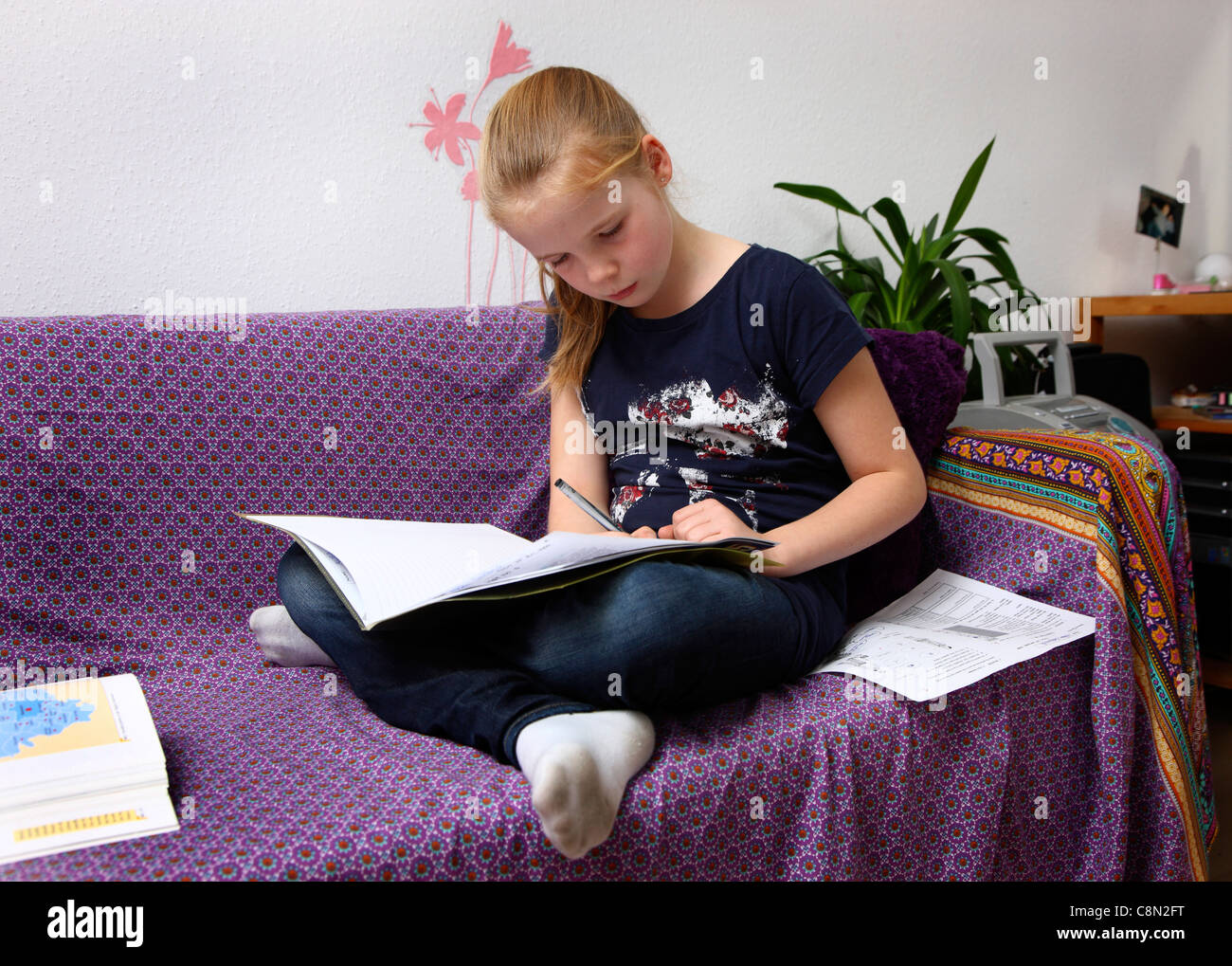 Fille, 10 ans, l'apprentissage de l'école, à la maison dans sa chambre, faire ses devoirs. Banque D'Images