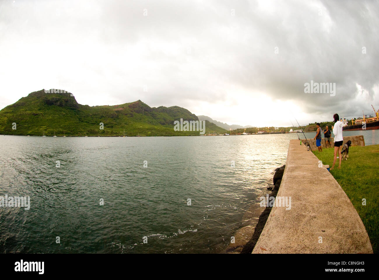 Les gens debout sur le mur du port de pêche à Lihue, rue Nawiliwili que vous suivrez, Kauai Banque D'Images