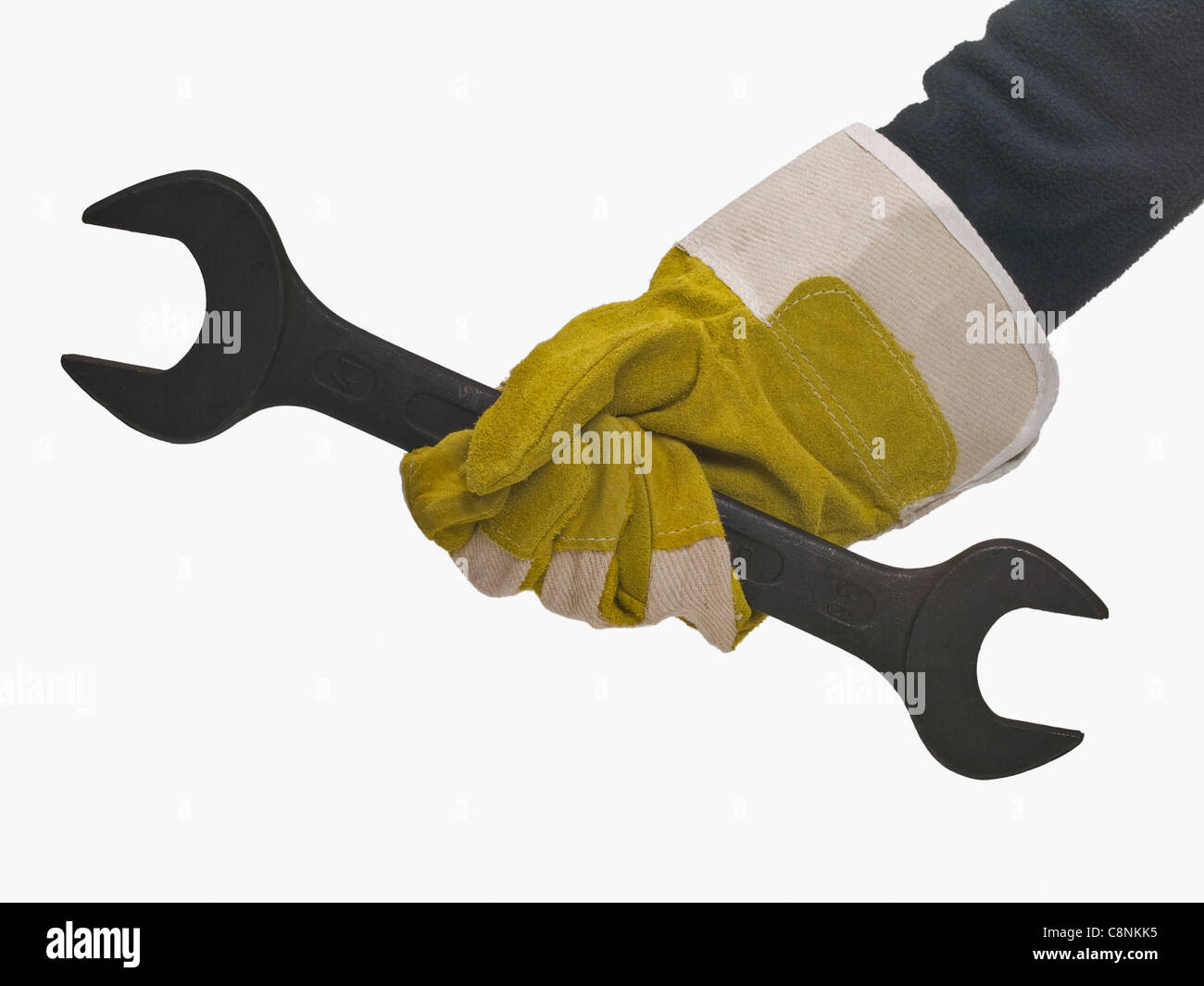 Une clé mixte sont tenues à la main avec des gants de protection Banque D'Images