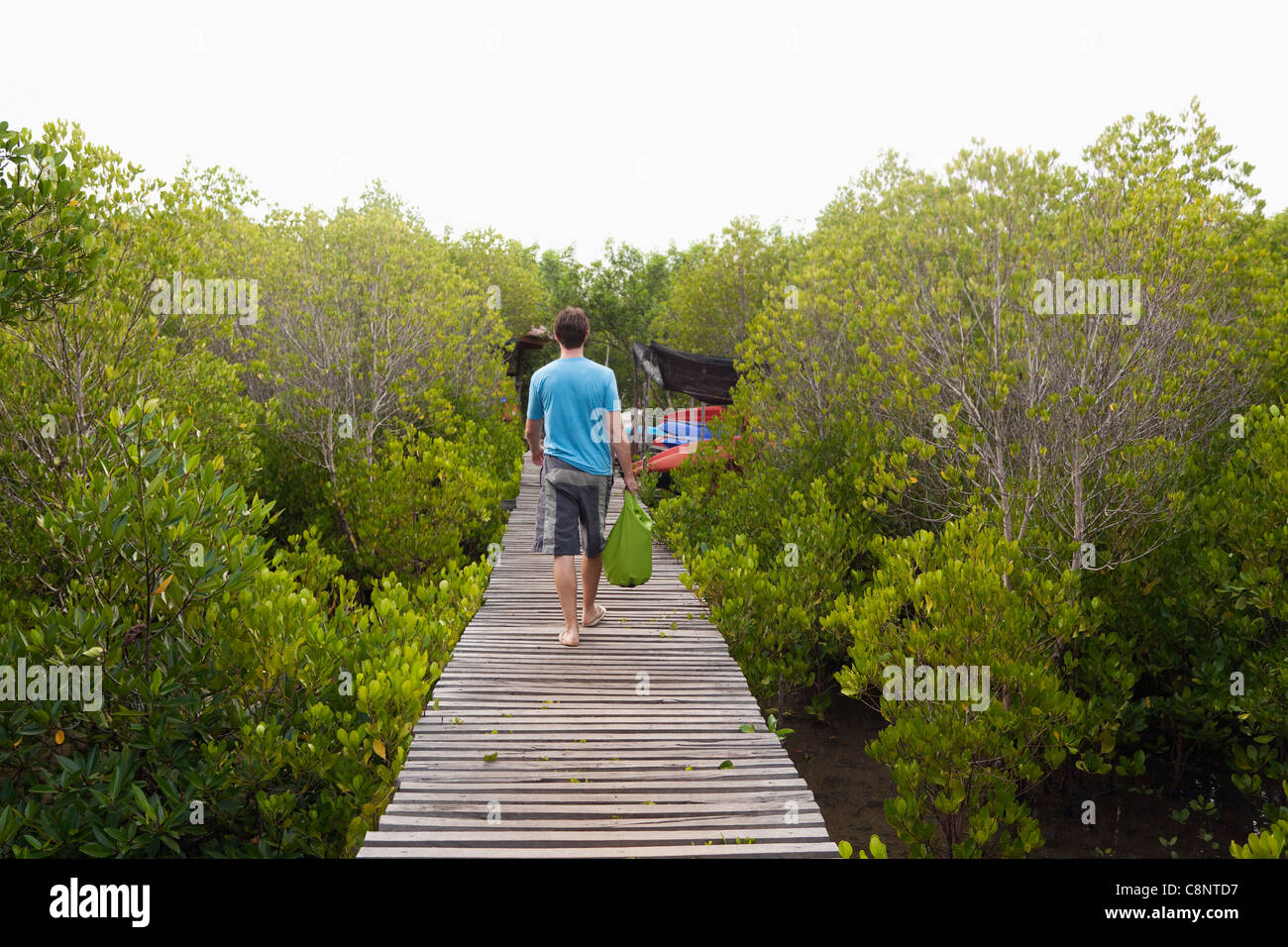 Caucasian man walking sur trottoir de bois Banque D'Images