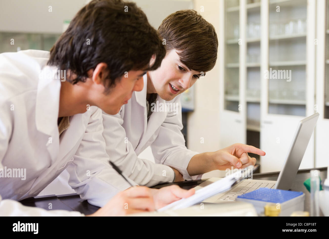 Smiling étudiants en chimie l'écriture d'un rapport Banque D'Images