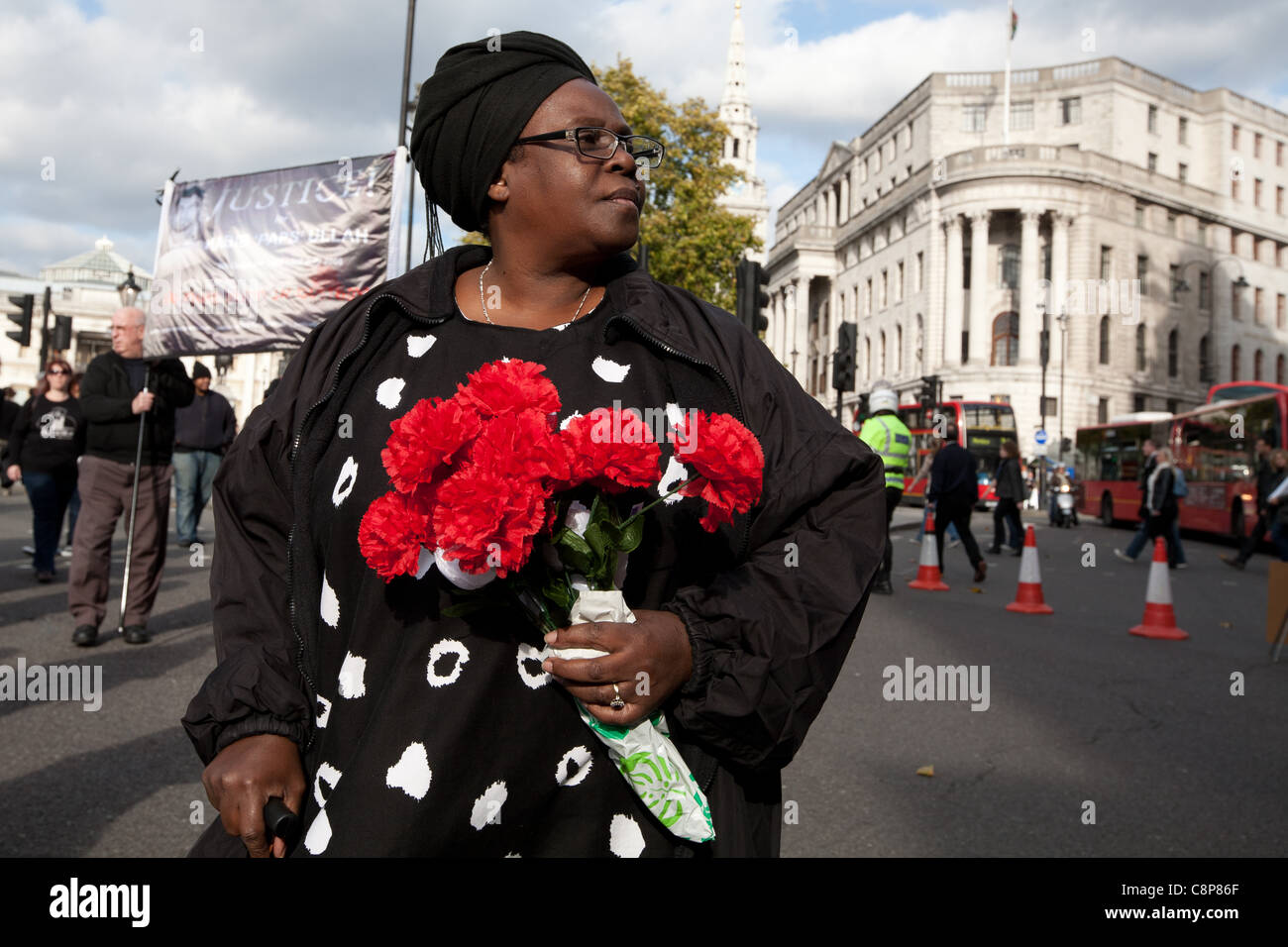 London, UK, 29/10/2011. NCAPV manifestant la marche pour Downing St holding red carnations Banque D'Images