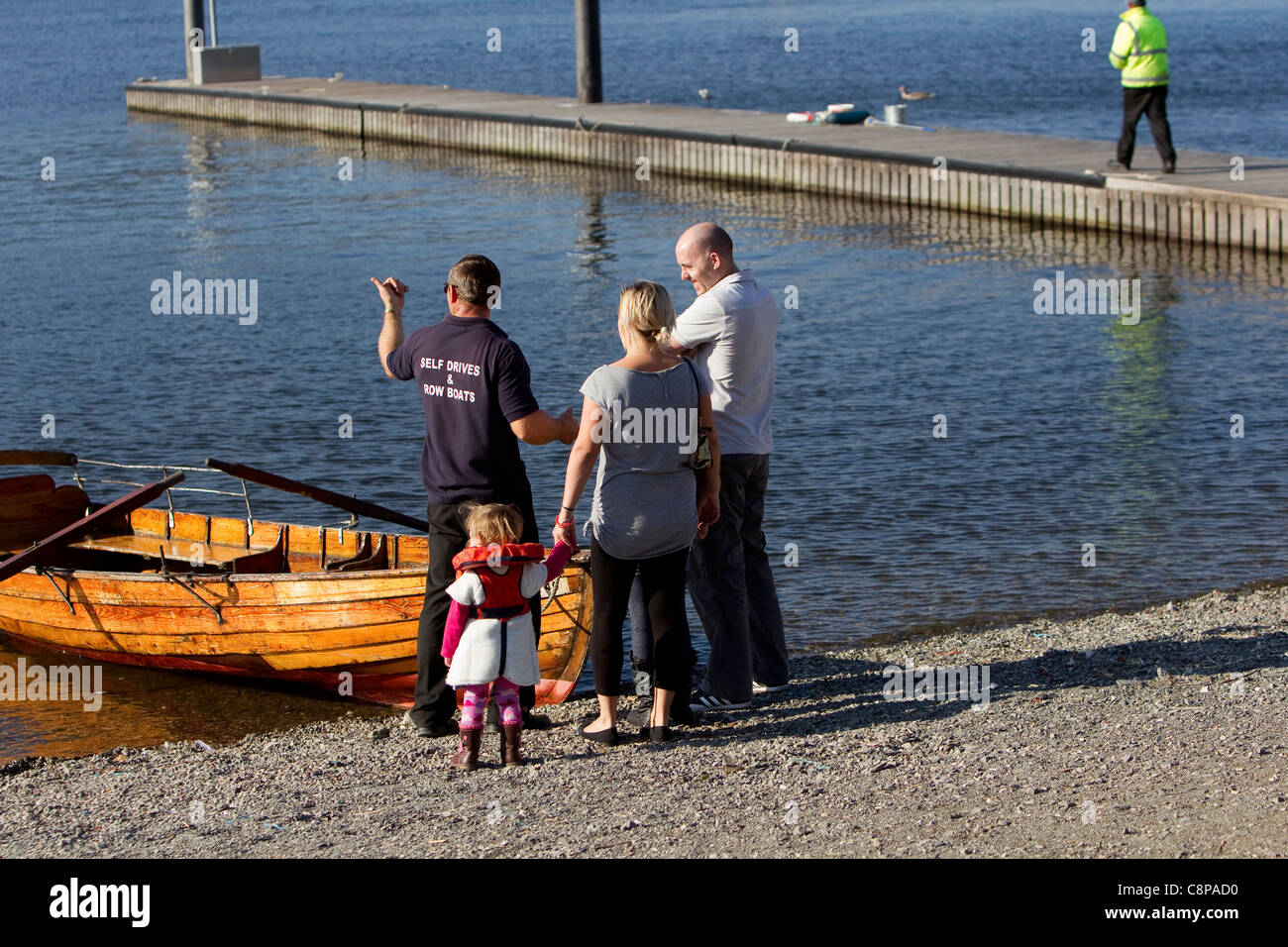 La famille de touristes prêts à utiliser un bateau à rames en bois sur le lac Windermere accordée par l'exposé sur la sécurité lacs Windermere Cruises Banque D'Images