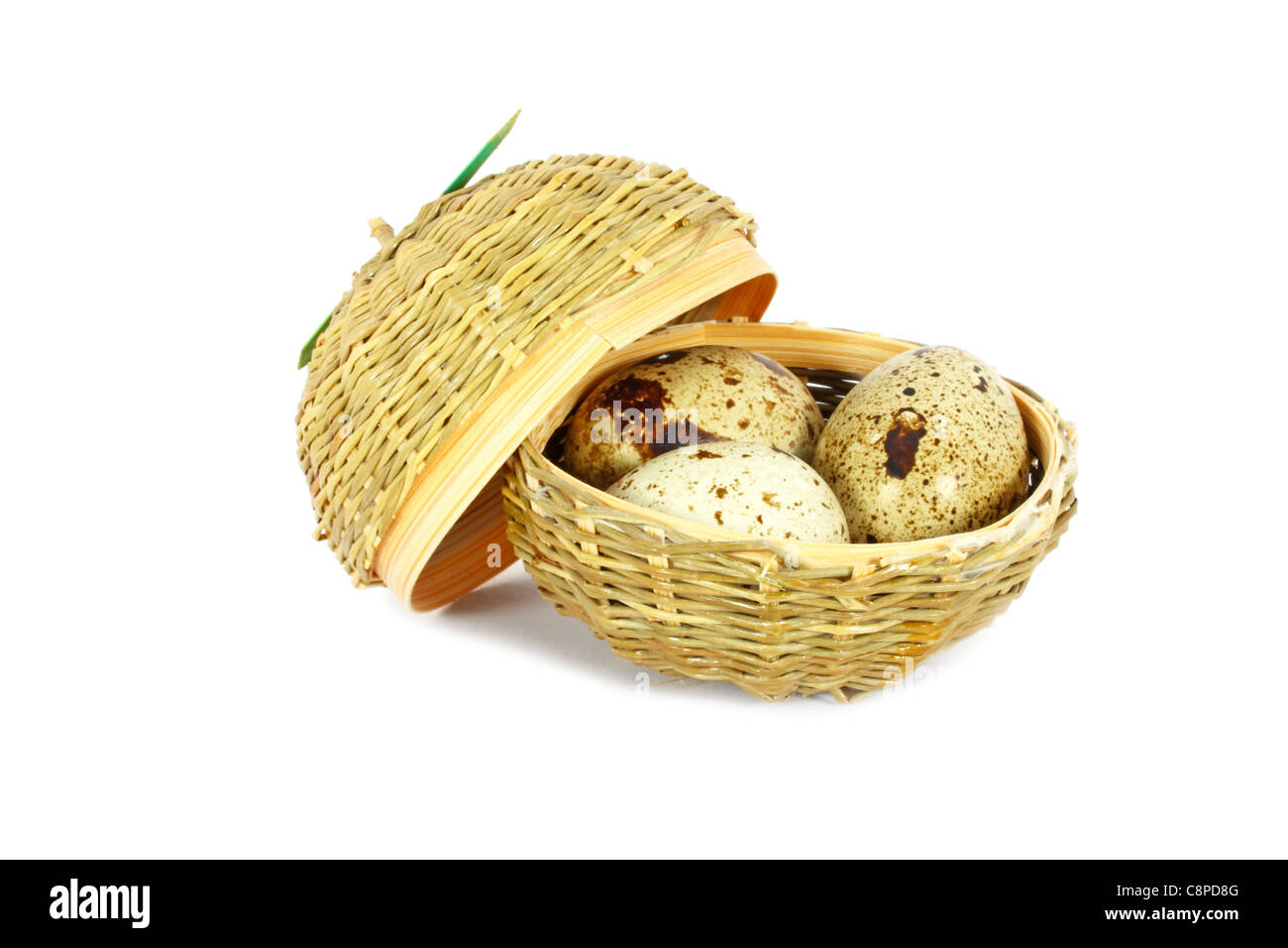 Trois oeufs de cailles du Japon dans un petit panier isolated on white Banque D'Images