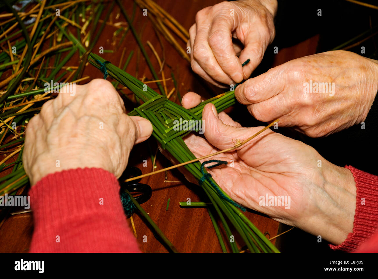 Mains faire une croix de Saint Brigid's l'un des rituels traditionnels en Irlande pour célébrer le début du début du printemps, le 1er février Banque D'Images