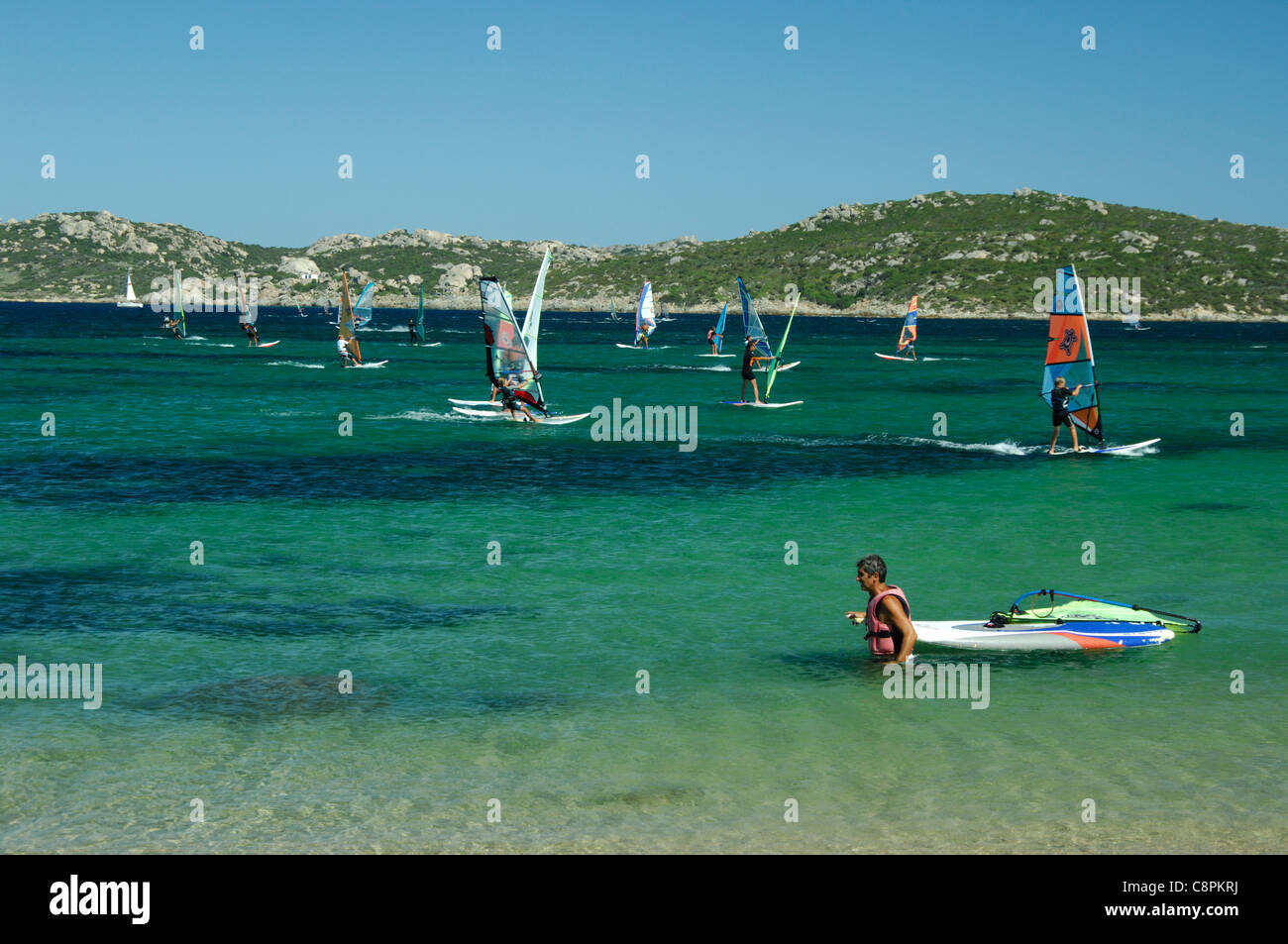 Homme retraite d'une compétition de planche à voile à la baie de Porto Pollo et de la plage, Palau, SARDAIGNE Banque D'Images