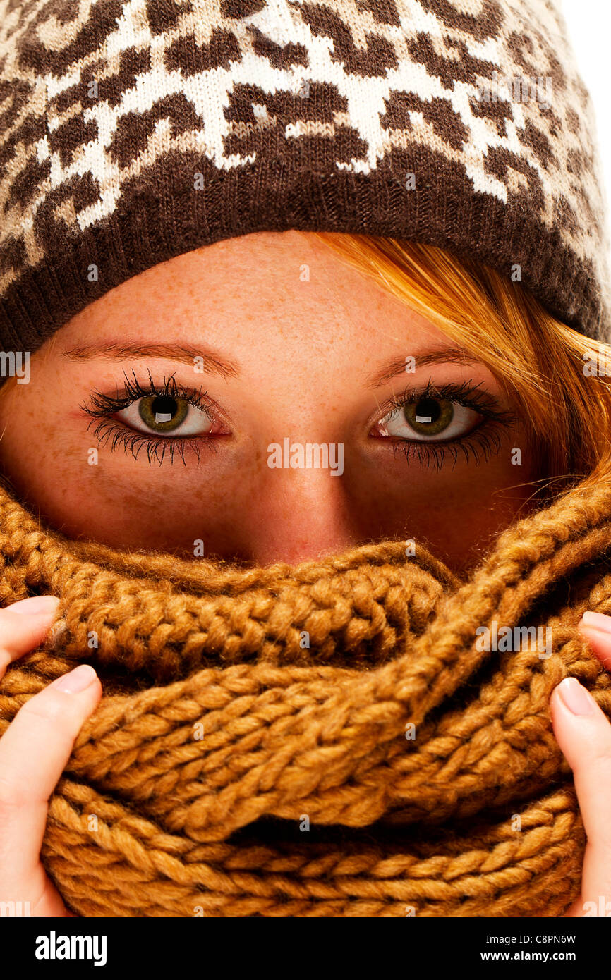 Jeune femme rousse avec écharpe de mode d'hiver se cacher derrière Banque D'Images