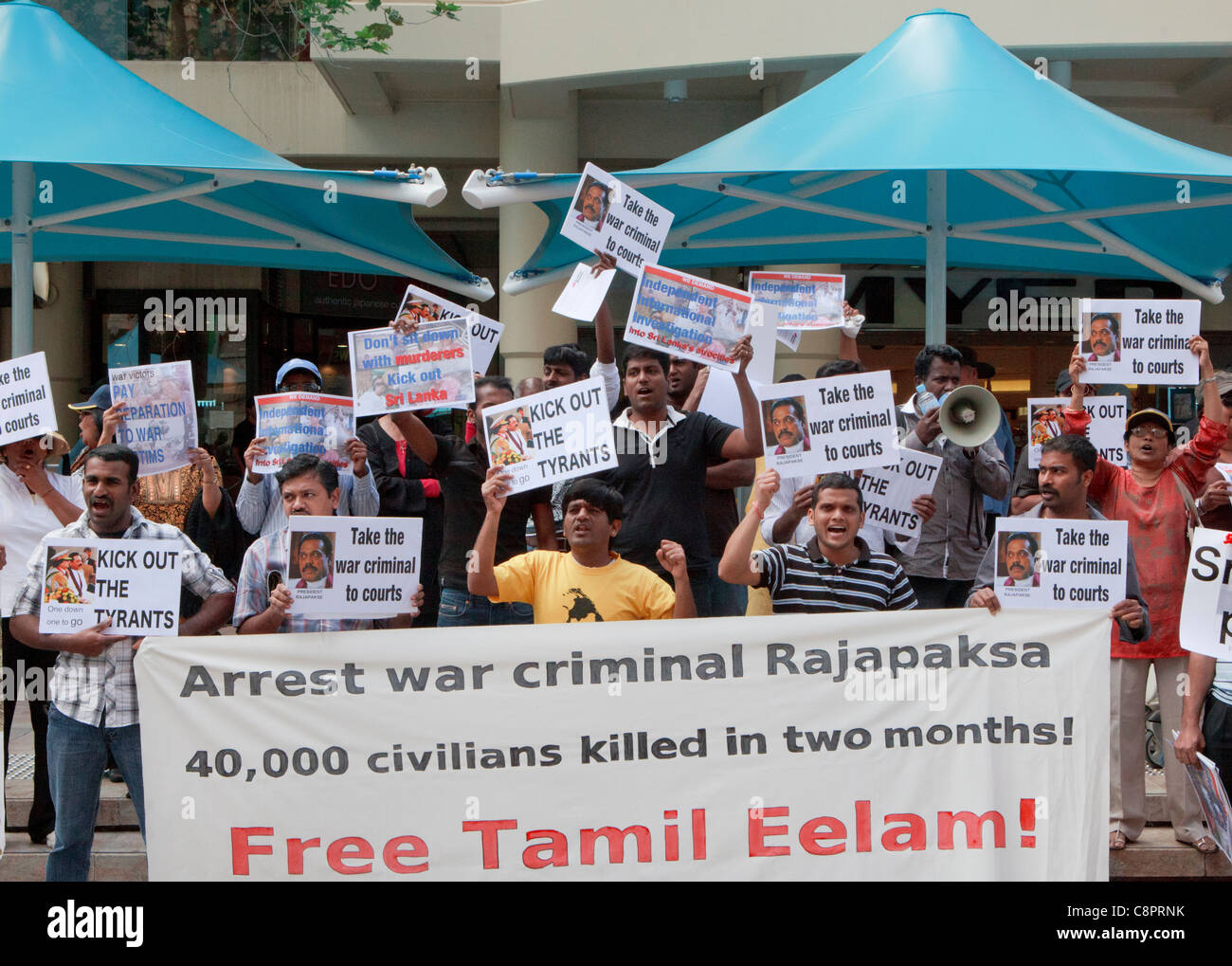 Les manifestants avec une bannière de l'Eelam tamoul qui manifestent contre le président du Sri Lanka, Mahendra Rajapakse au CHOGM 2011 manifestations. Banque D'Images