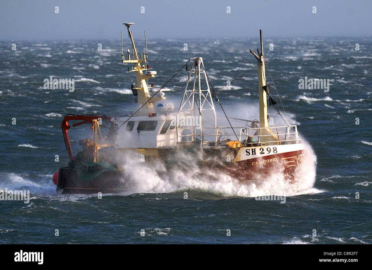 Un bateau de pêche par le biais de forts vents têtes tom Scarborough Harbour Banque D'Images