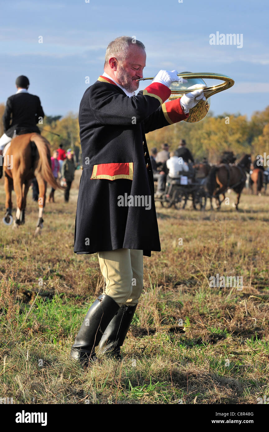 Huntsman portant manteau noir soufflant cor de chasse au cours de Saint Hubert / Saint Hubertus commémoration à l'automne, de l'Europe Banque D'Images