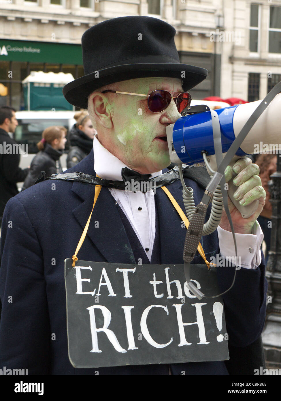 Un manifestant avec une "Mangez les riches !" lors d'une manifestation anti-capitaliste Banque D'Images