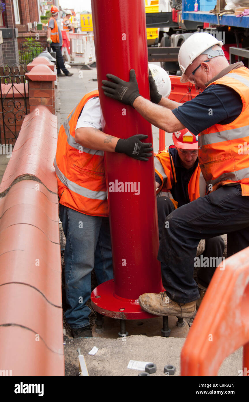 L'érection d'un équipement de Lignes aériennes (OHLE) pôle, à l'Est de la ligne de Manchester Metrolink tram, Manchester, Angleterre, RU Banque D'Images