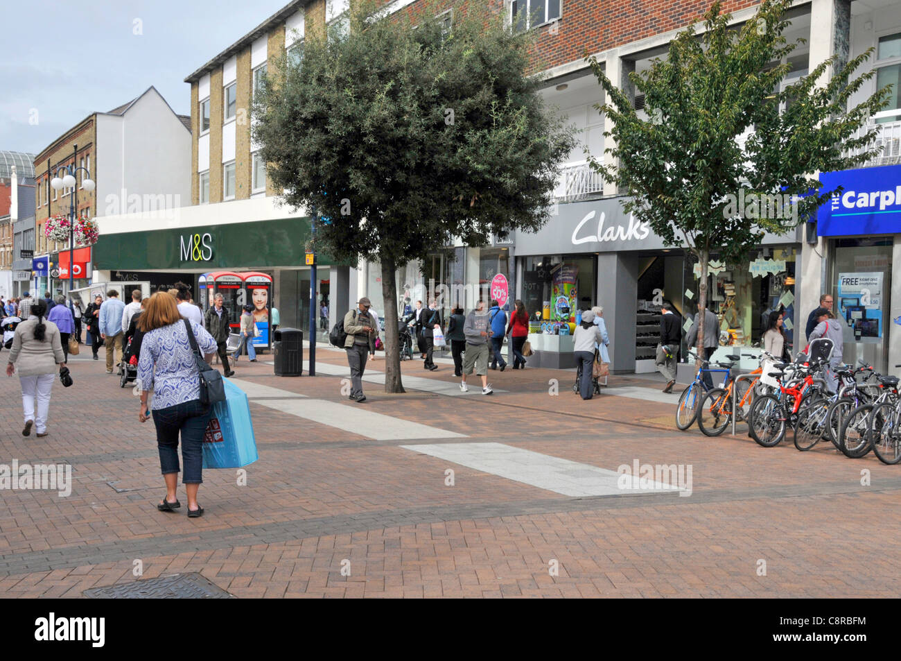 Scène de rue les gens font du shopping dans les rues piétonnes de Kingston upon Thames High Street inclut M&S et Clarks magasins à l'ouest de Londres Angleterre Royaume-Uni Banque D'Images