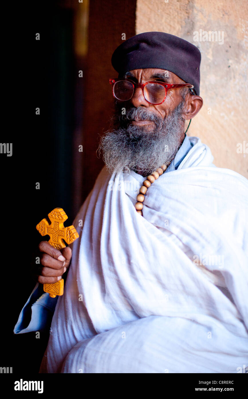 Portrait d'un prêtre chrétien orthodoxe debout dans l'embrasure de la porte à l'église de rupestres à Wukro Chirkos, Nord de l'Ethiopie. Banque D'Images