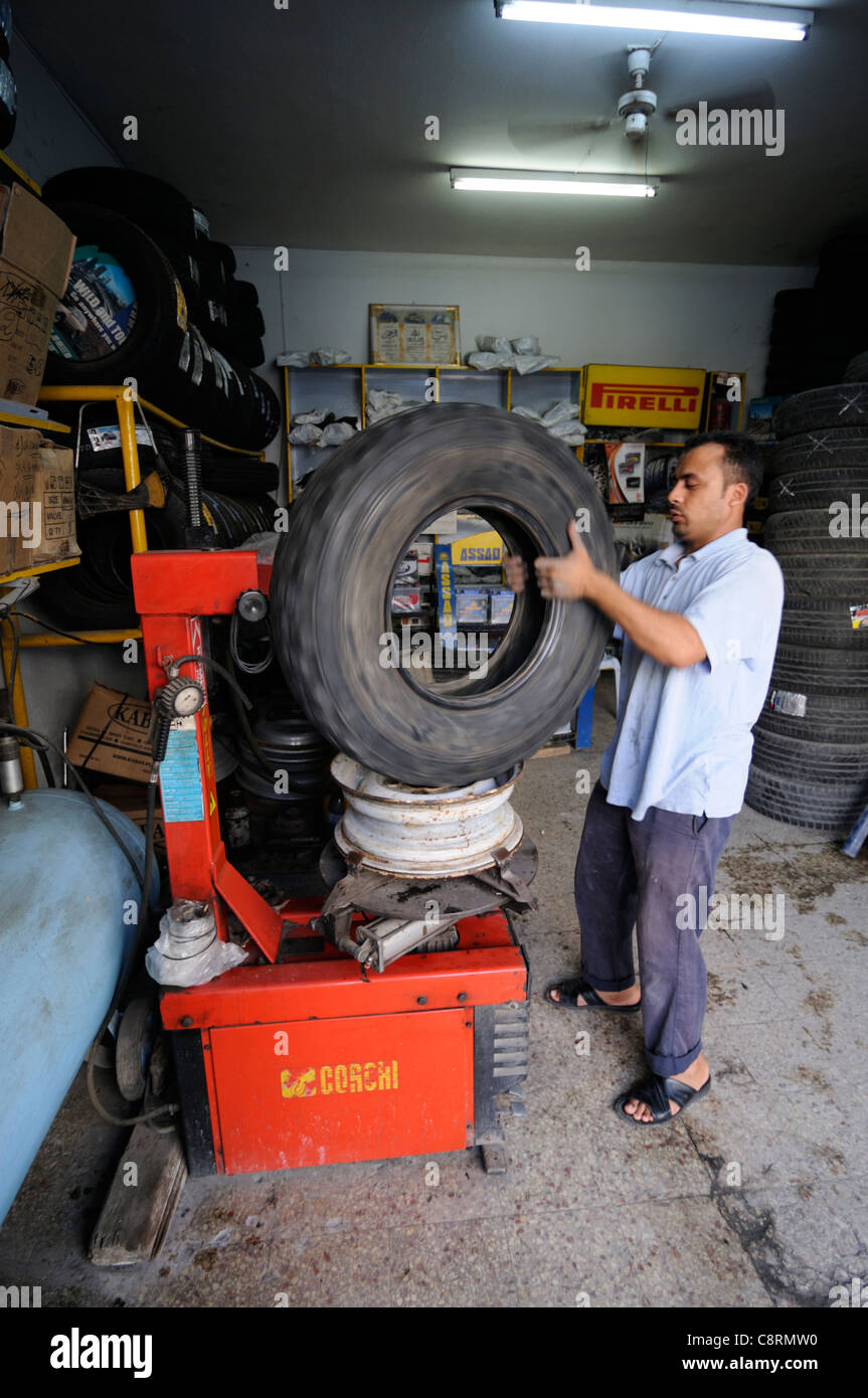 L'Afrique, Tunisie, Nabeul. Mécanicien tunisien local en réparant une crevaison du pneu sur un pneu Michelin sable XS. Banque D'Images