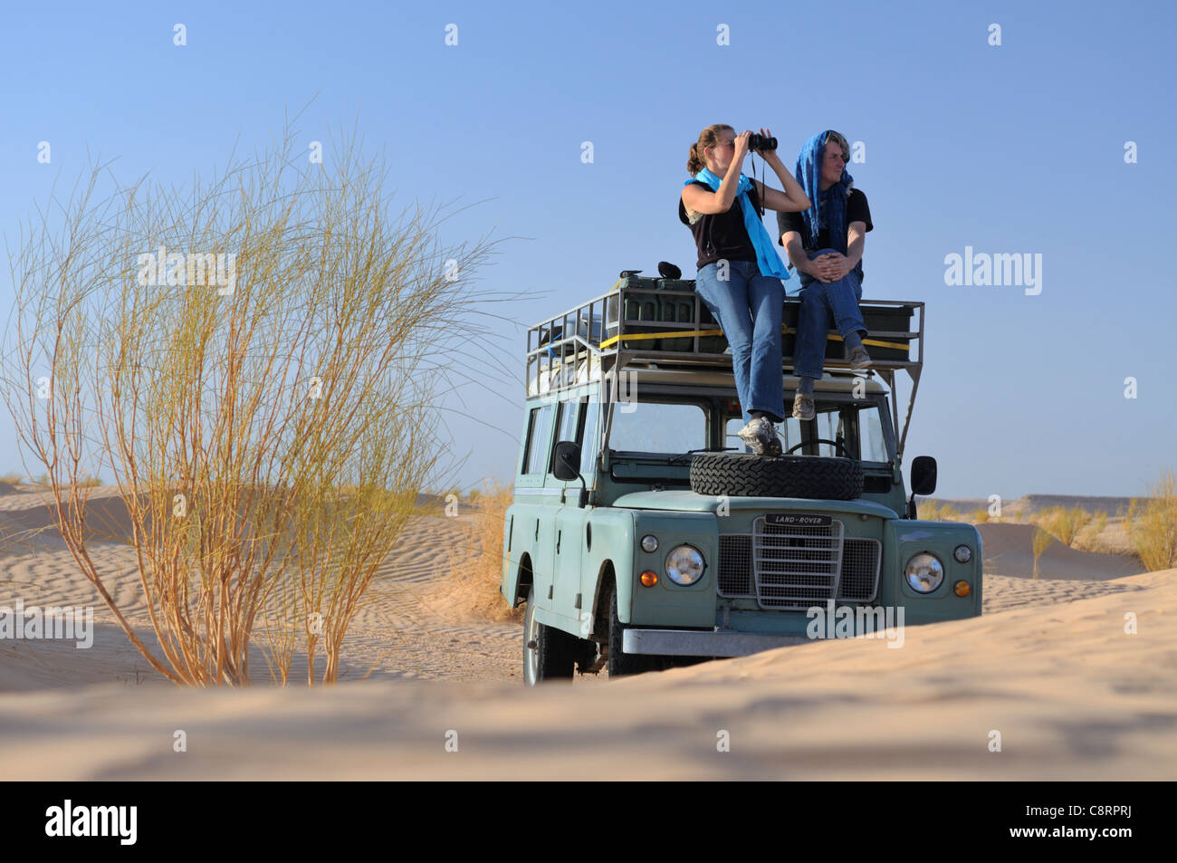 L'Afrique, Tunisie, nr. Tembaine. Les voyageurs du désert profitant de la vue sur le désert du Sahara s'asseoir sur leurs lieux historiques ... Banque D'Images
