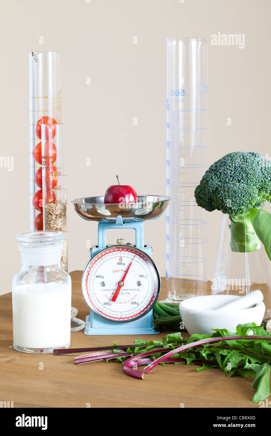 Apple sur une balance avec l'équipement de laboratoire sur fond blanc Banque D'Images