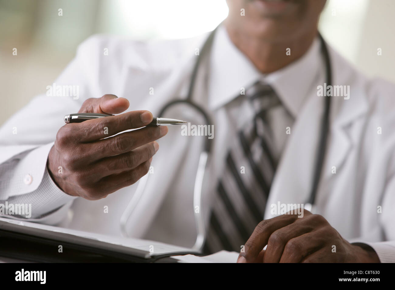 African American doctor writing in medical record Banque D'Images African American doctor writing in medical record Banque D'Images