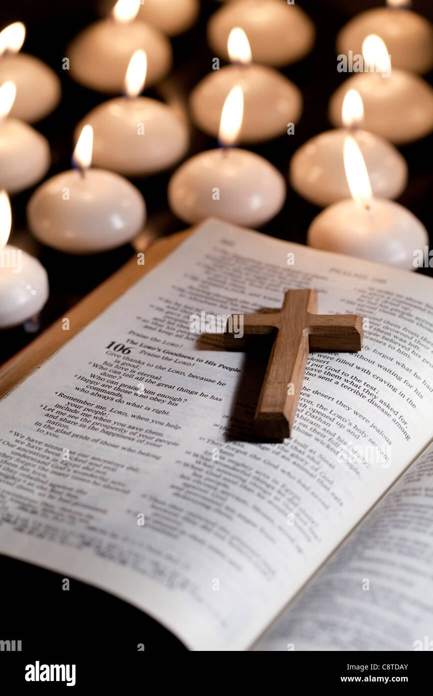 Couché sur la sainte bible avec des bougies à l'arrière-plan Banque D'Images