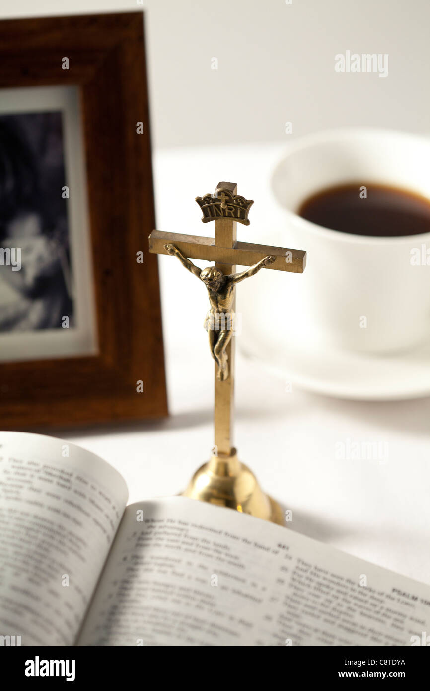 Bible ouverte avec crucifix, cadre photo et le thé noir en arrière-plan Banque D'Images
