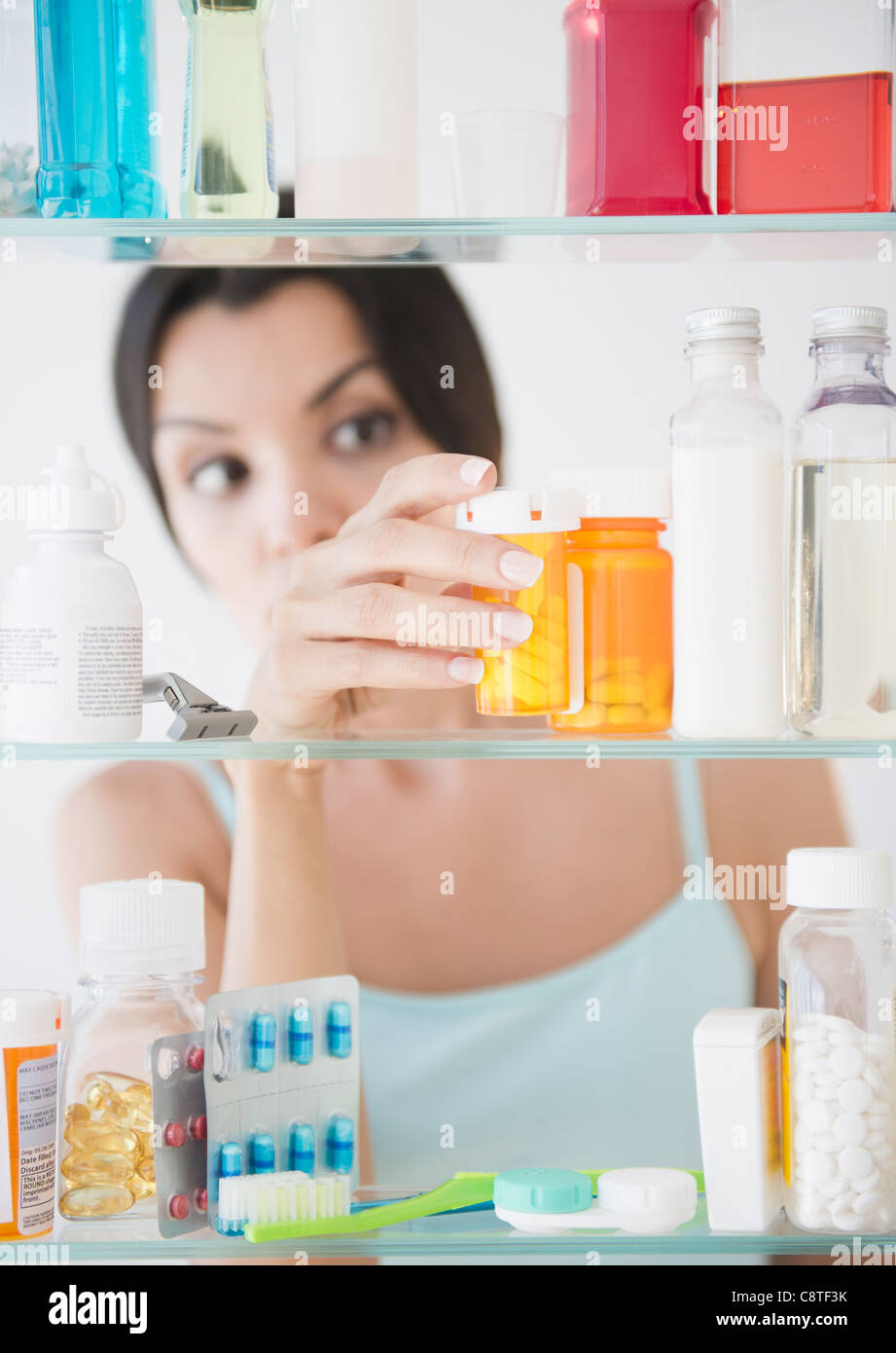 USA, New Jersey, Jersey City, Woman taking medicine cabinet de Banque D'Images