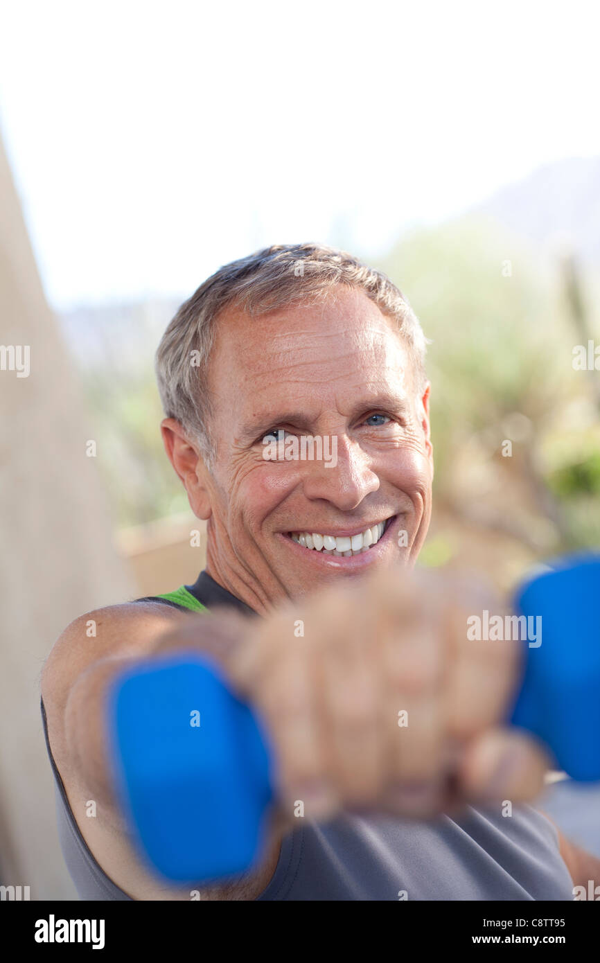 USA, Arizona, Phoenix, Portrait of senior man lifting dumbbells Banque D'Images