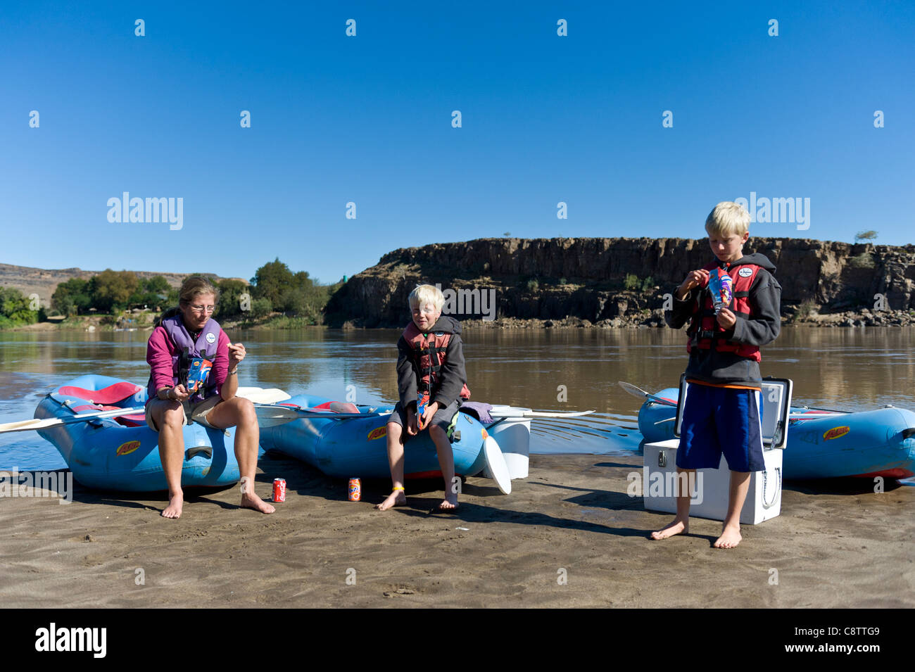 Mère et enfants faites une pause au cours d'un voyage de rafting sur la rivière Oranje à Noordoewer Namibie Banque D'Images