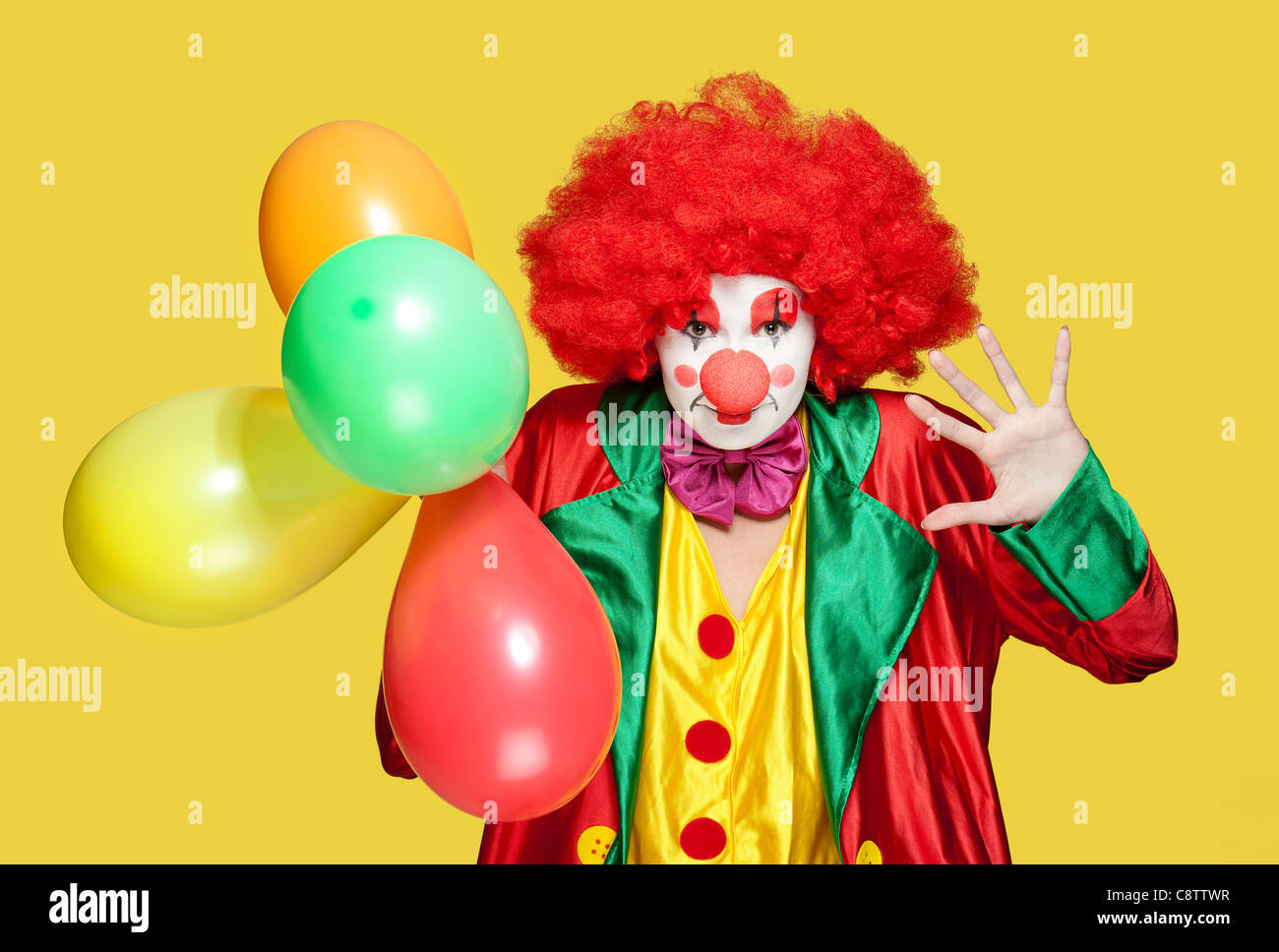 Un clown féminin avec des vêtements colorés et un miroir Banque D'Images