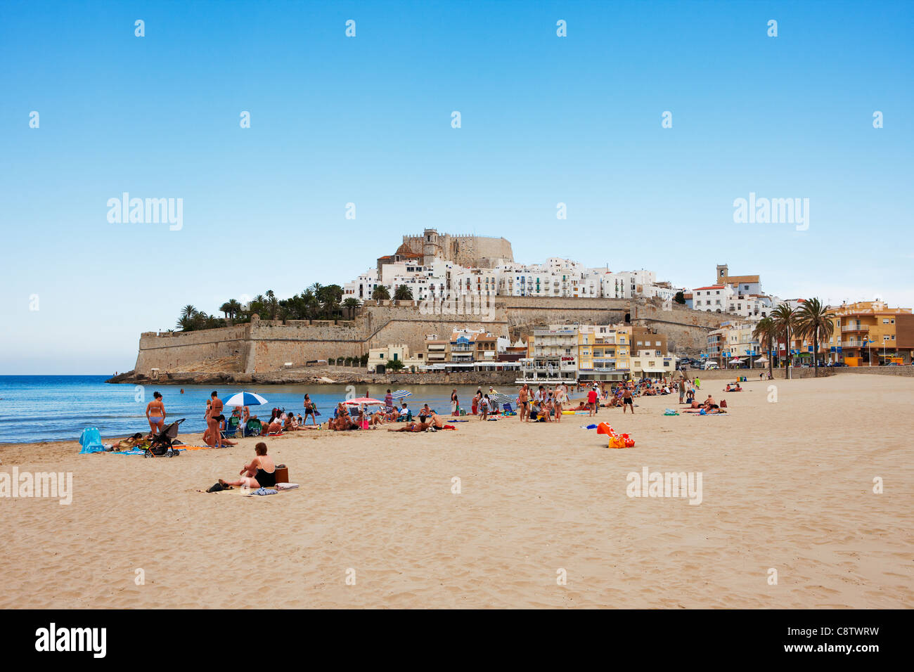 Les gens prennent le soleil sur une plage de sable près de la forteresse Peniscola. Peniscola, Communauté valencienne, Costa Del Azahar, Espagne. Banque D'Images