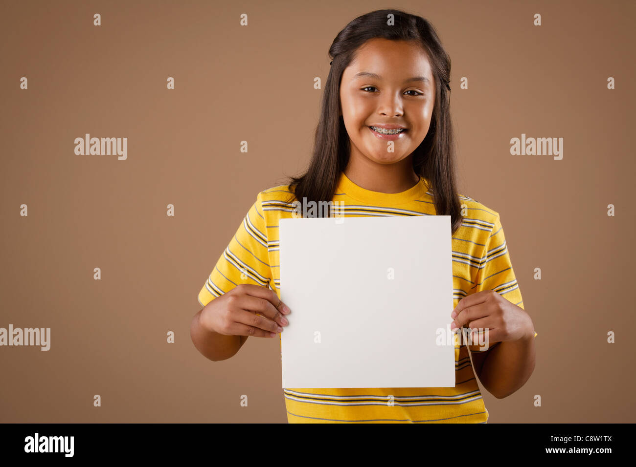 Studio Portrait of Girl holding feuille de papier vierge Banque D'Images