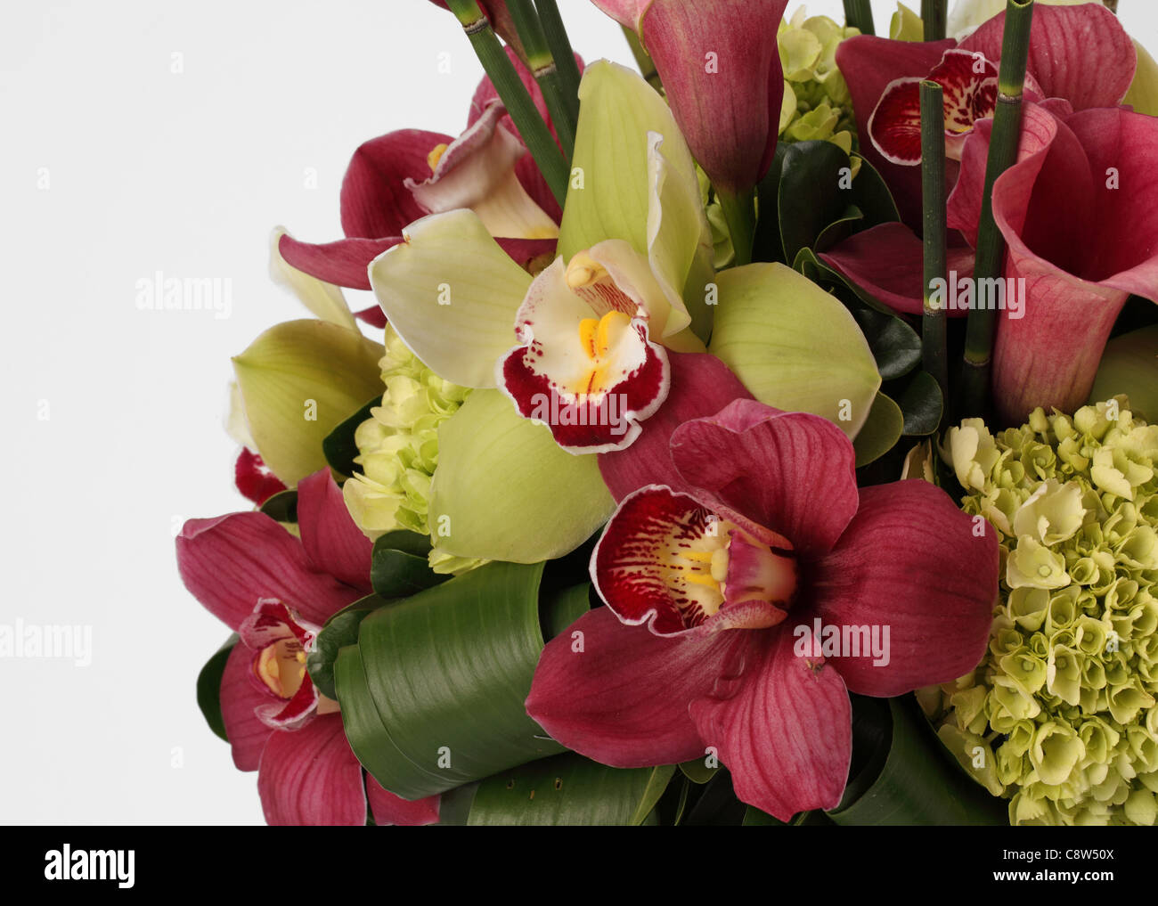 Un gros plan d'un bouquet de fleurs colorées. Des lis calla rose, vert et rouge les orchidées cymbidiums Banque D'Images