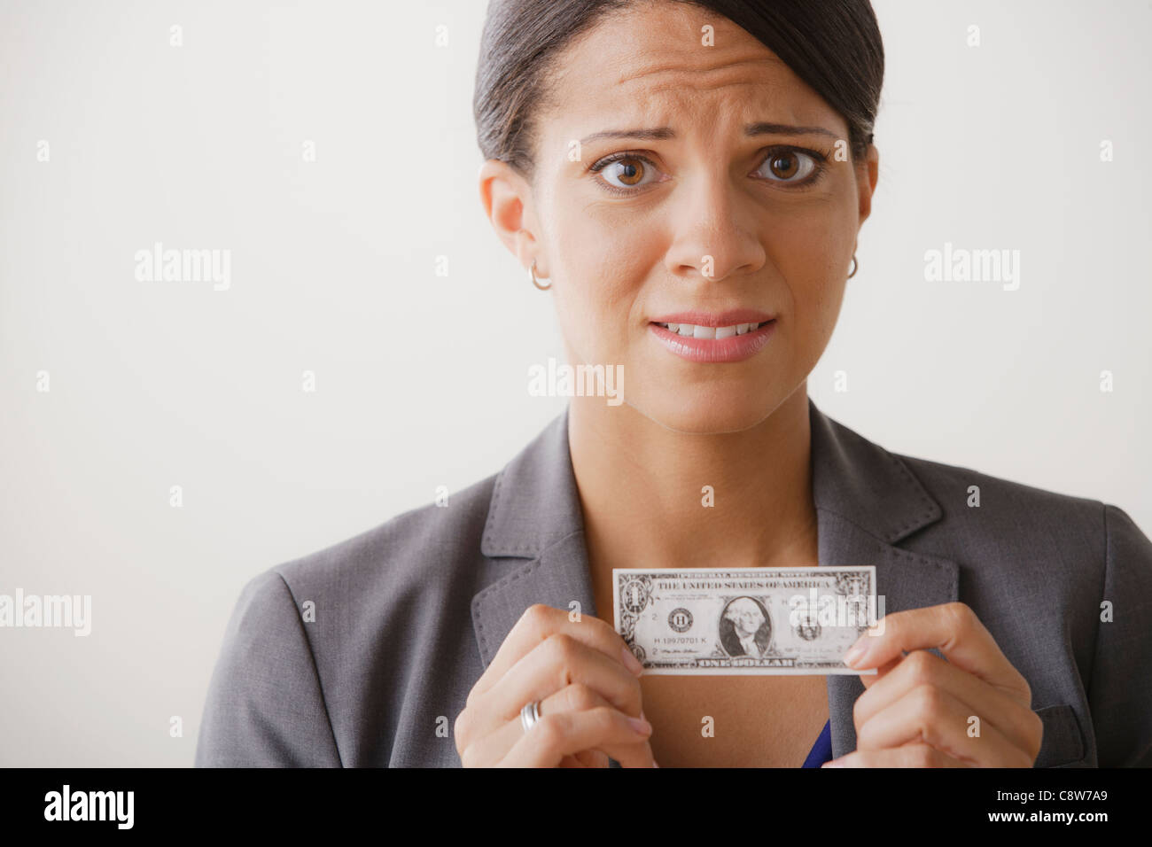 Studio shot of business woman holding small one dollar bill Banque D'Images