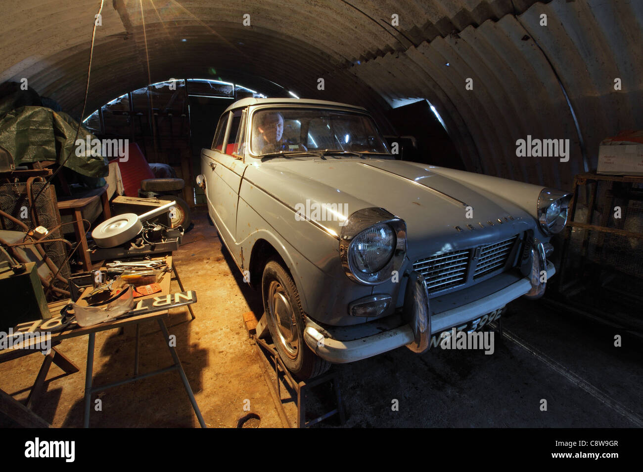 Les amateurs de voitures classiques, assis dans Triumph Herald coupé, voiture, projet en rénovation, en garage atelier Banque D'Images
