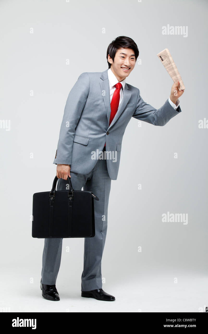 Asian Businessman Hailing part avec porte-documents et presse Banque D'Images