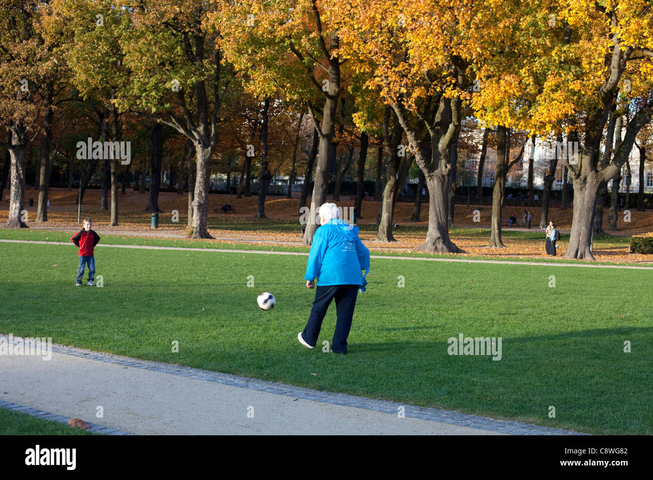 Grand-mère et petit-fils joue au football dans un parc Banque D'Images