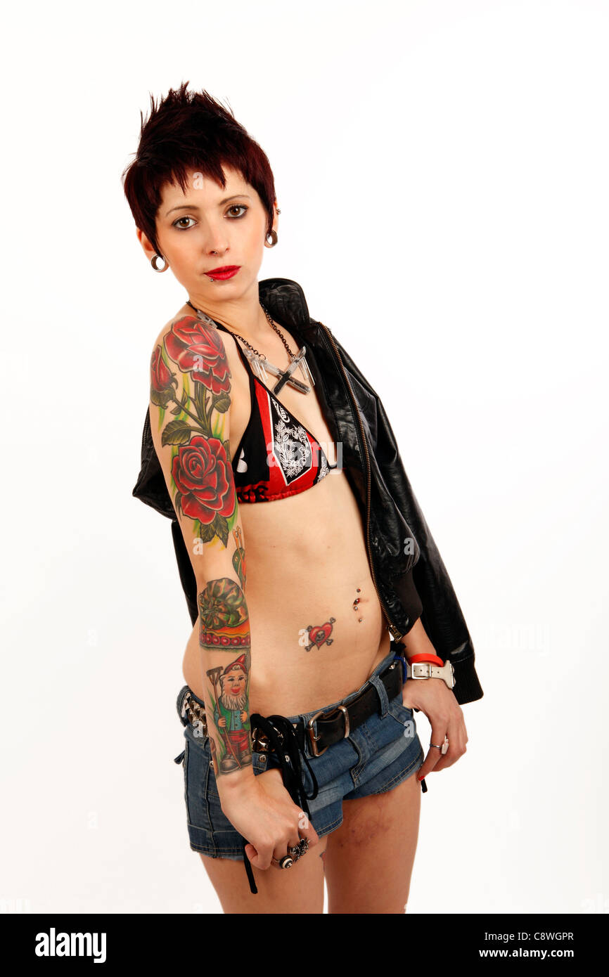 Jeune femme dans un bikini et short avec des tatouages sur son bras Banque D'Images