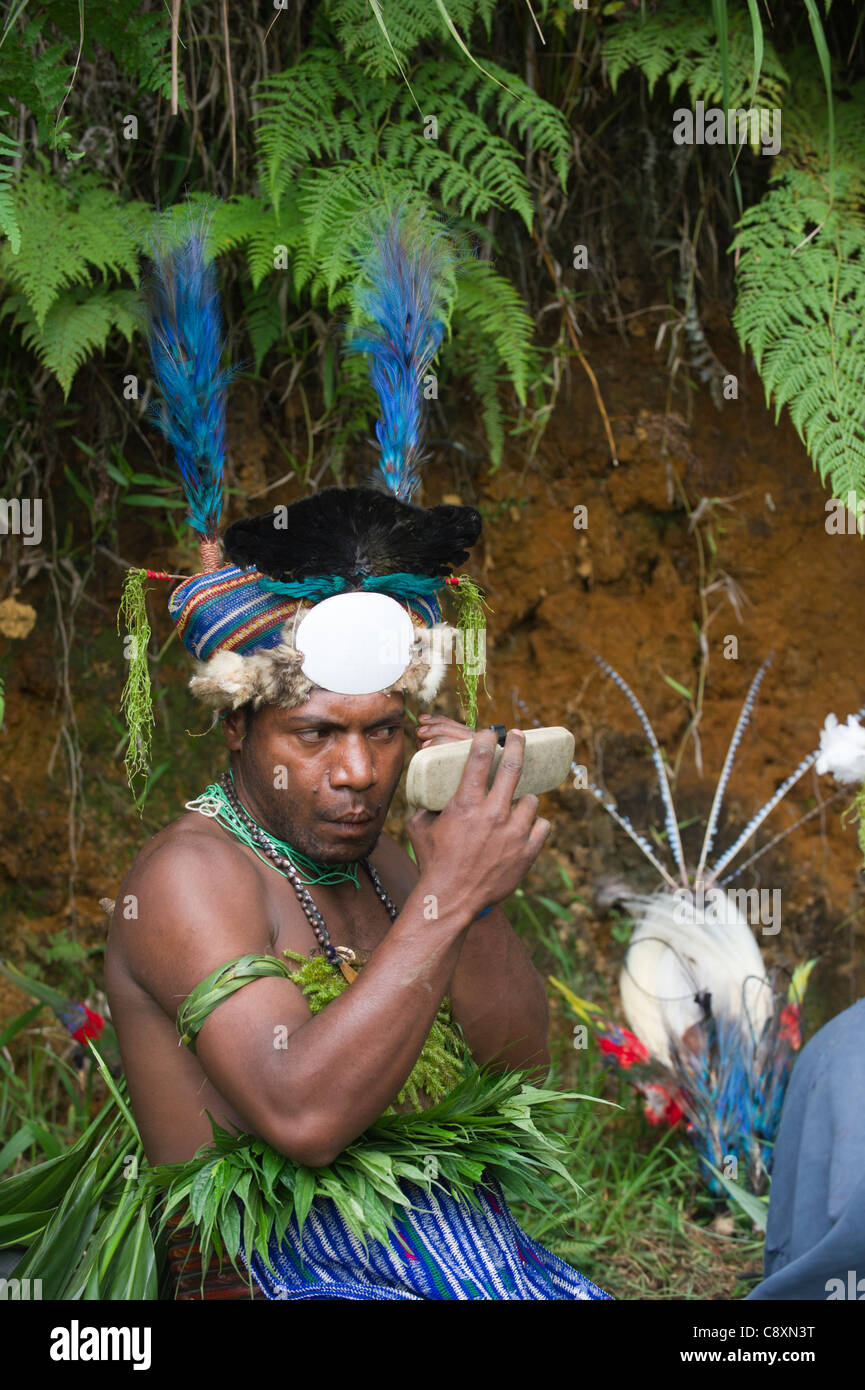 L'interprète se préparer à chanter chanter à Paiya en hautes terres de l'ouest de la Papouasie-Nouvelle-Guinée. Remarque Blue Bird of Paradise feathers Banque D'Images
