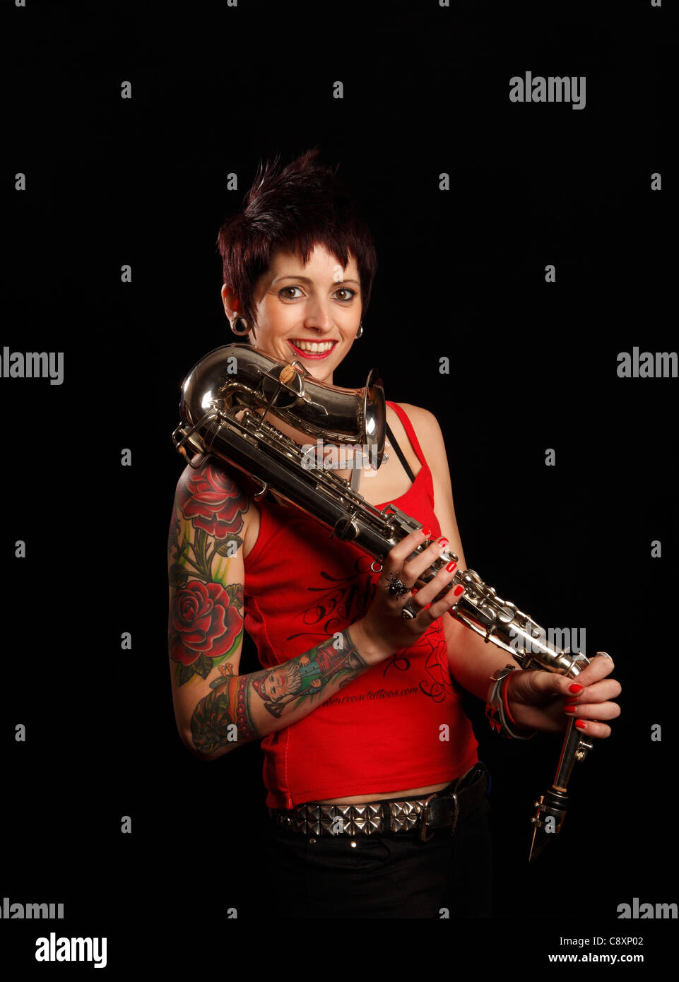 Saxophoniste femelle avec des tatouages sur son bras Banque D'Images