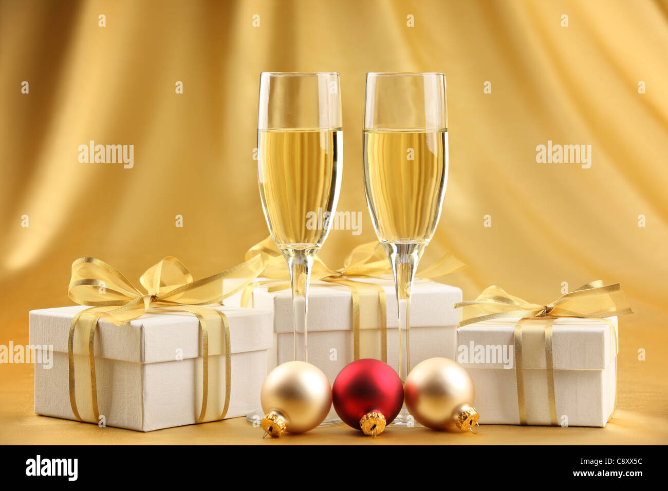 Verres de champagne avec des boîtes-cadeaux et boules de Noël. Banque D'Images
