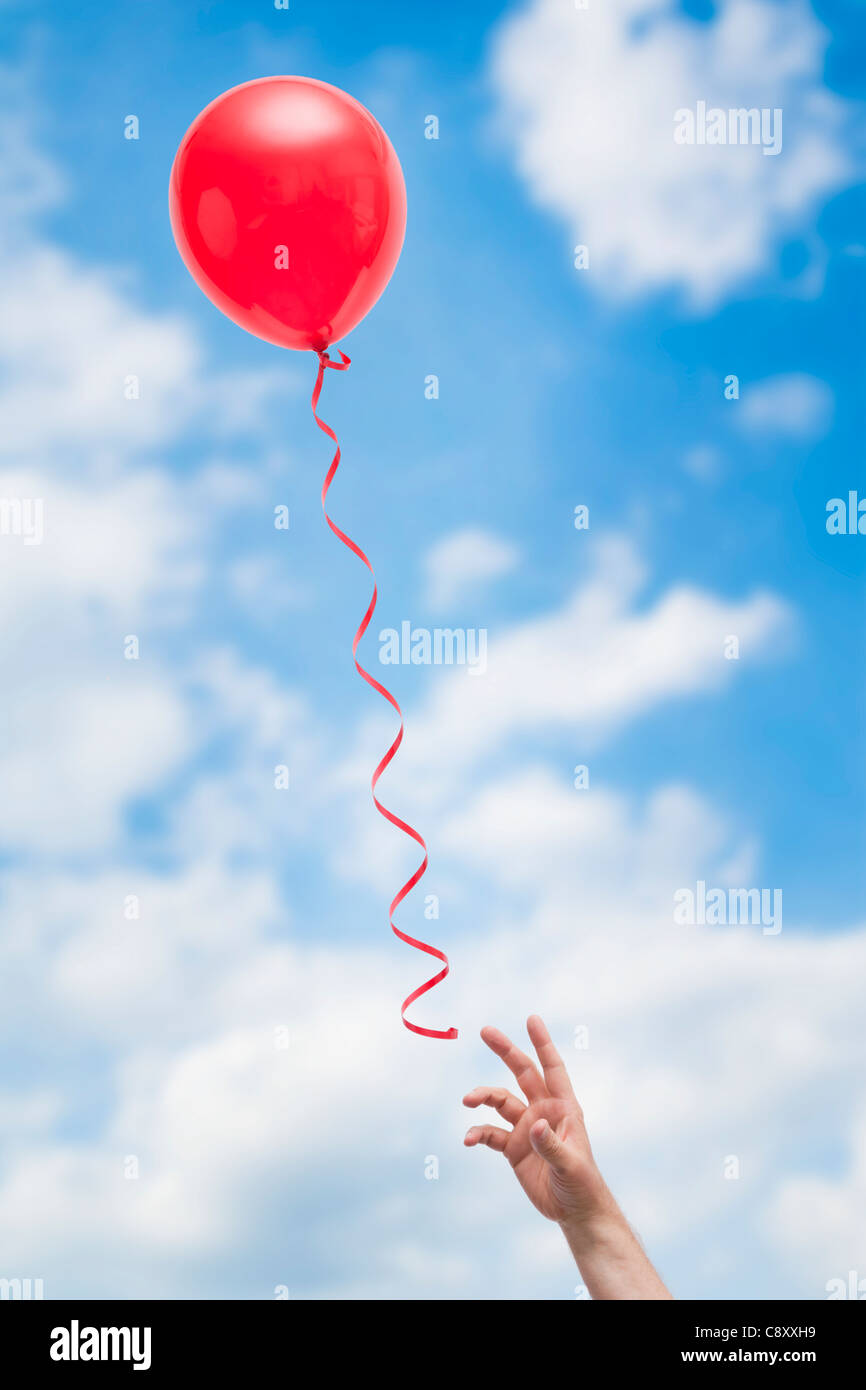 États-unis, Illinois, Metamora, hand reaching for ballon rouge Banque D'Images