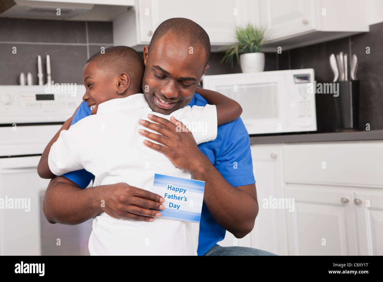 États-unis, Illinois, Metamora, Man holding father's day card et embrassant son (6-7) Banque D'Images