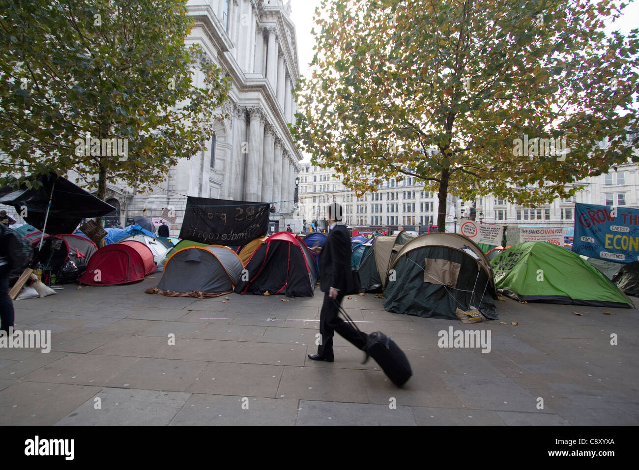 Les travailleurs de la ville naviguent dans la zone tandis que les manifestants d’Occupy London poursuivent leur camp devant la cathédrale St Paul, Londres, Royaume-Uni Banque D'Images