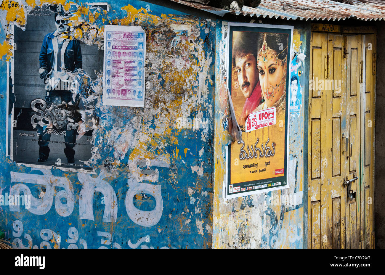Affiches de films indiens sur un mur en lambeaux d'une vieille maison de l'Inde rurale. L'Andhra Pradesh, Inde Banque D'Images Affiches de films indiens sur un mur en lambeaux d'une vieille maison de l'Inde rurale. L'Andhra Pradesh, Inde Banque D'Images