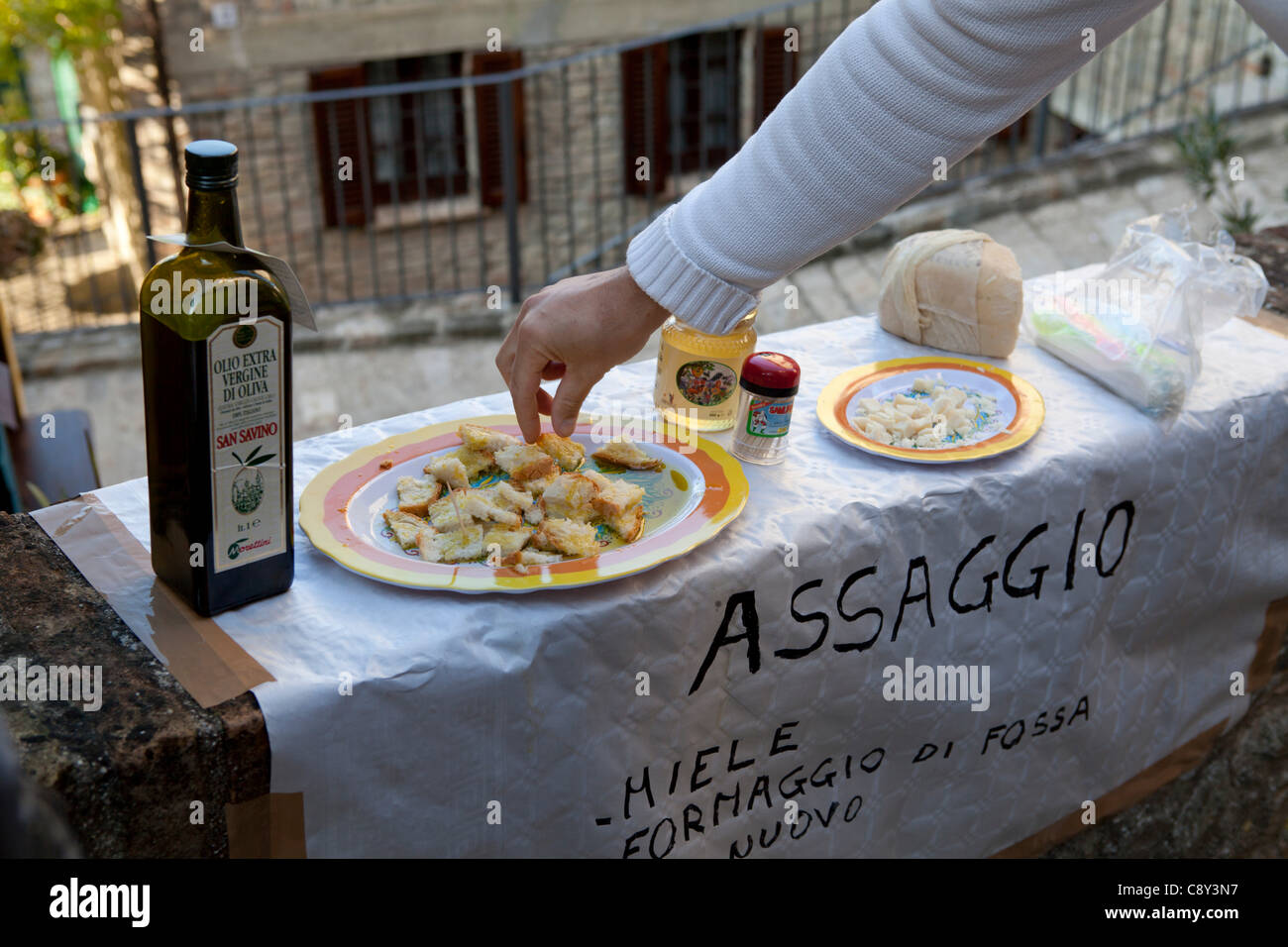 Dégustation de tourisme la nouvelle huile d'olive avec du pain pour le festival du bois pendant la toussaint week-end à Montone, Pérouse, Ombrie, Italie. Boutique externe temporaire mis en place pour le festival dans l'étroite rue du village médiéval. 28/29/30-10 et 1/11/2011 Banque D'Images