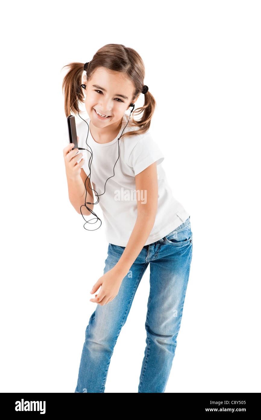 Petite fille danser tandis que d'écouter la musique avec un lecteur MP3, isolated on white Banque D'Images