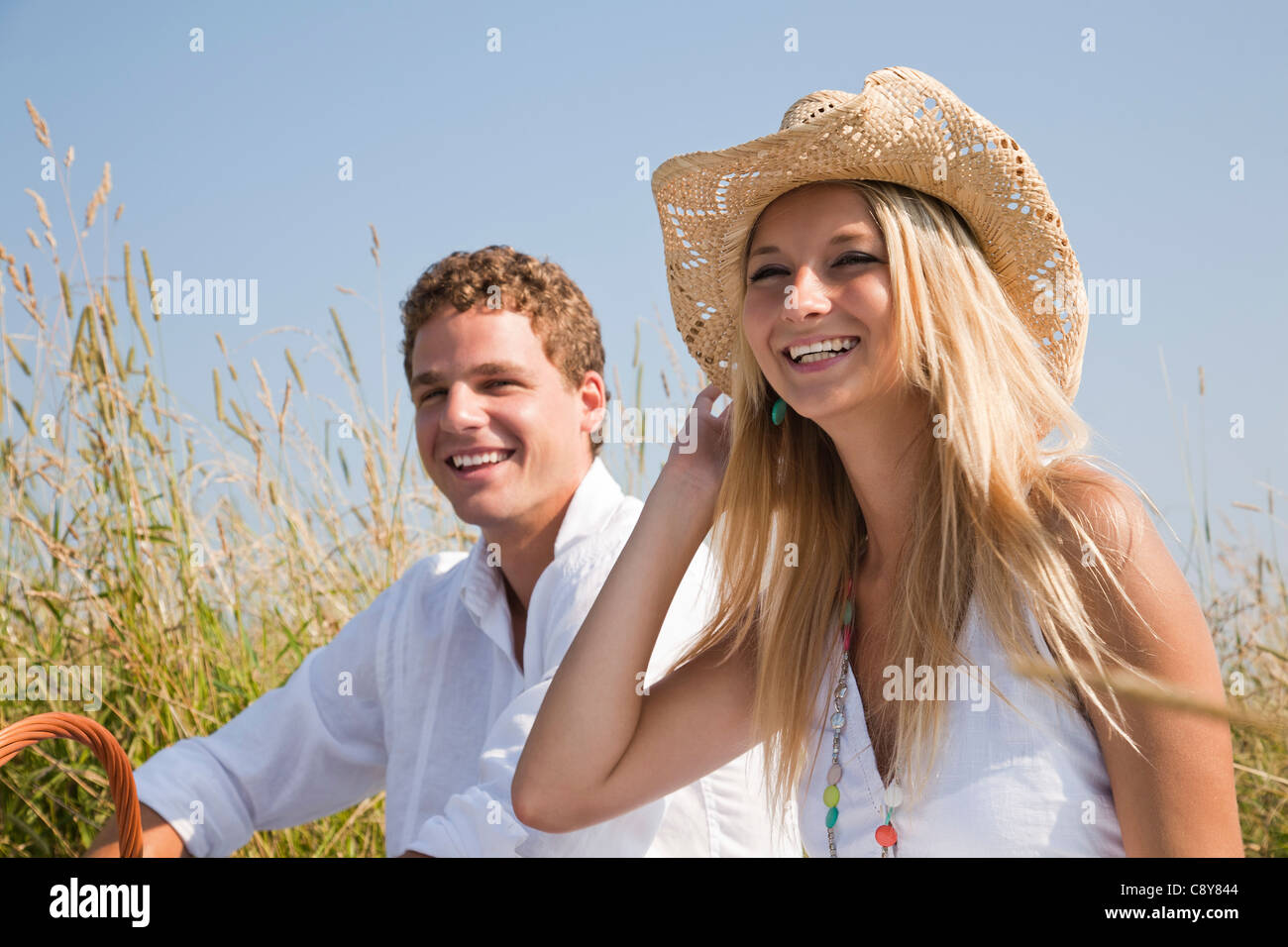 Portrait of young couple having picnic in meadow Banque D'Images