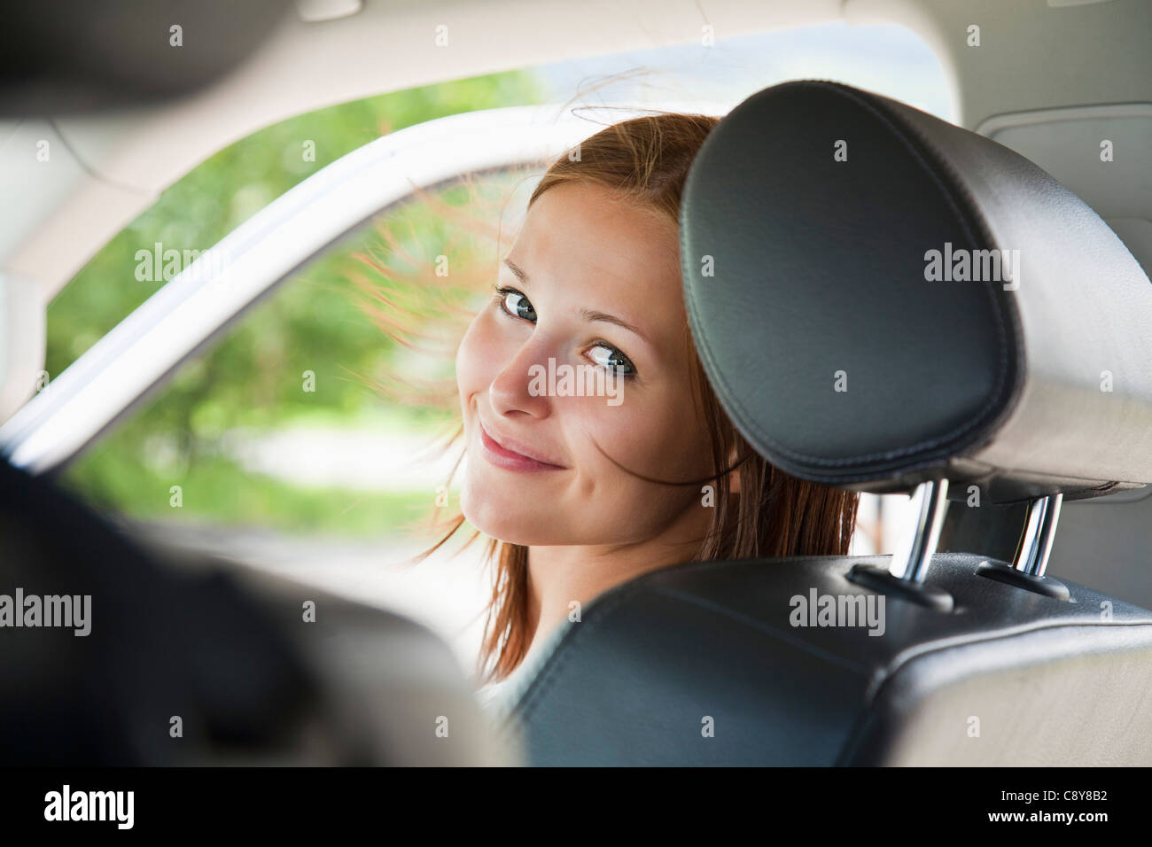 Portrait of young woman sitting in car Banque D'Images